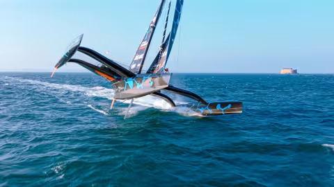 Upwind, slightly luffing prevents the windward float from lifting too much, while the  small C-shaped foil on the leeward side  manages to lift the trimaran slightly,  relieving the pressure on the rig.
