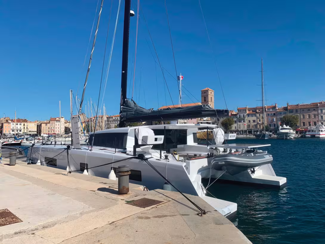 The combination of white hulls and black rig, structural elements and  hardware is a design success. Note the solar panel support on the davits  and the graduated daggerboards.